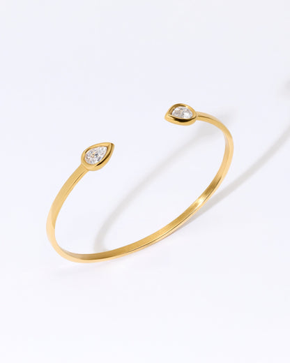 Gold bangle bracelet with two teardrop shaped crystal cz gemstones.