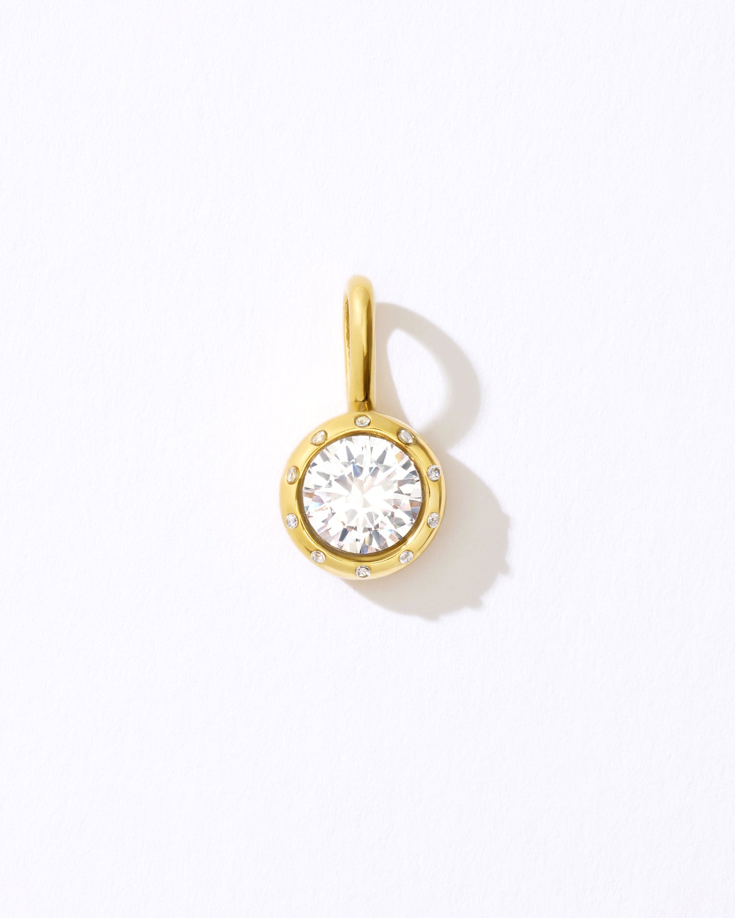 Gold pendant with a clear gemstone.
