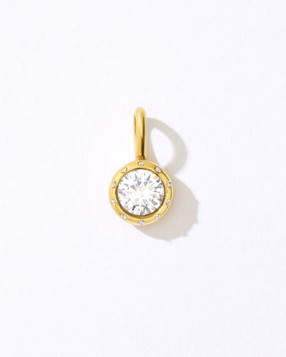 Gold pendant with a clear gemstone.