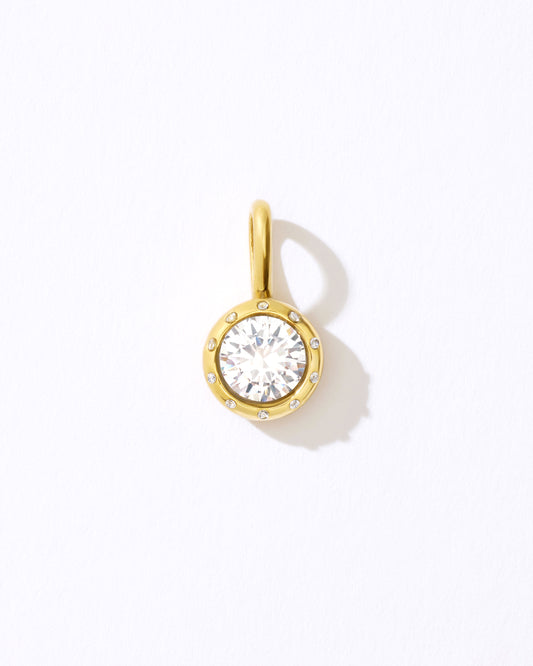 Gold pendant with a clear gemstone.