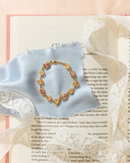 Meg Bracelet laying on an open book with blue cloth and lace.