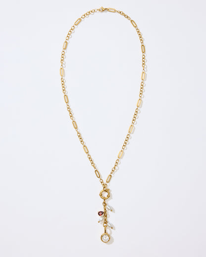 Gold Necklace with charms and pendants on a white background. 