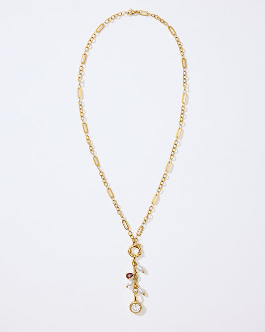Gold Necklace with charms and pendants on a white background. 