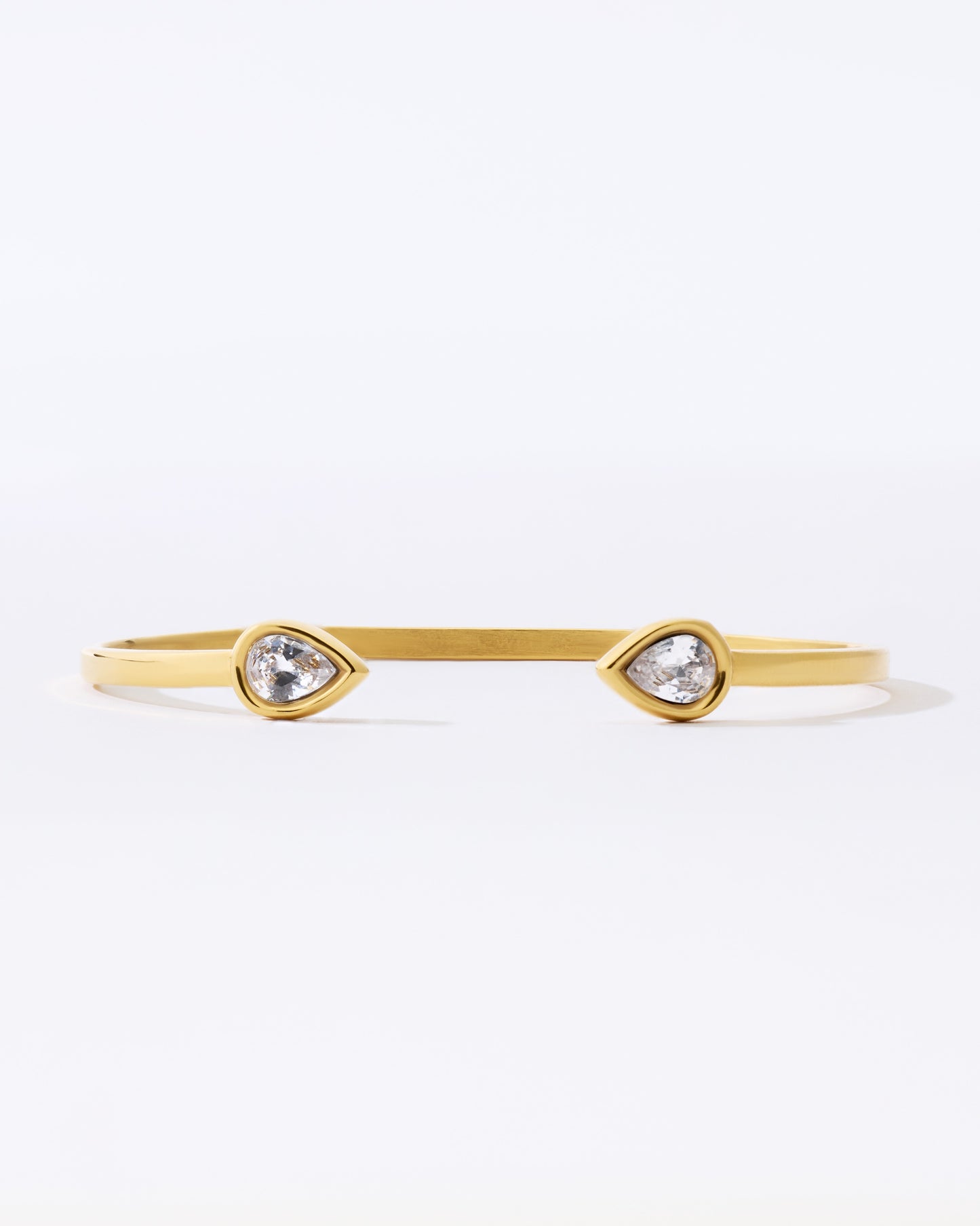 Gold bracelet with teardrop-shaped crystals on a white background
