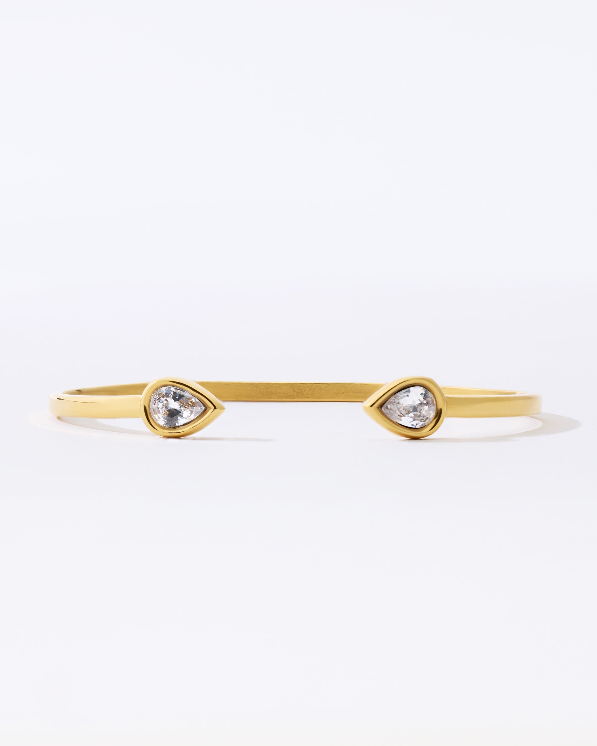 Gold bracelet with teardrop-shaped crystals on a white background