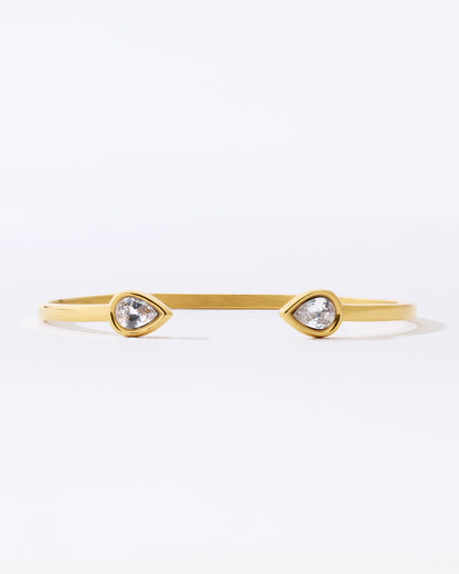 Gold bracelet with teardrop-shaped crystals on a white background