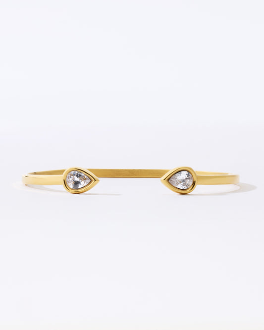 Gold bracelet with teardrop-shaped crystals on a white background