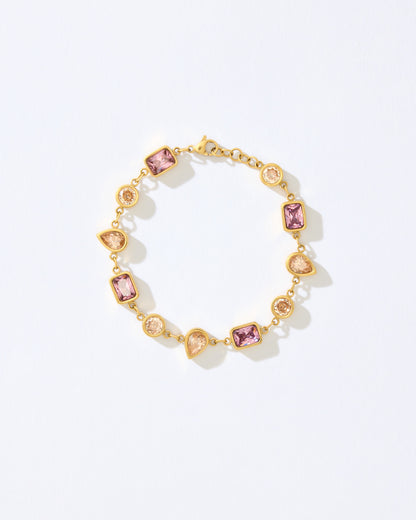 Gold bracelet with pink and orange gemstones on a white background